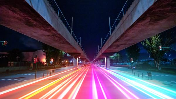 Visualizing 5G with colorful light trails connecting urban spots in finite vanishing point.